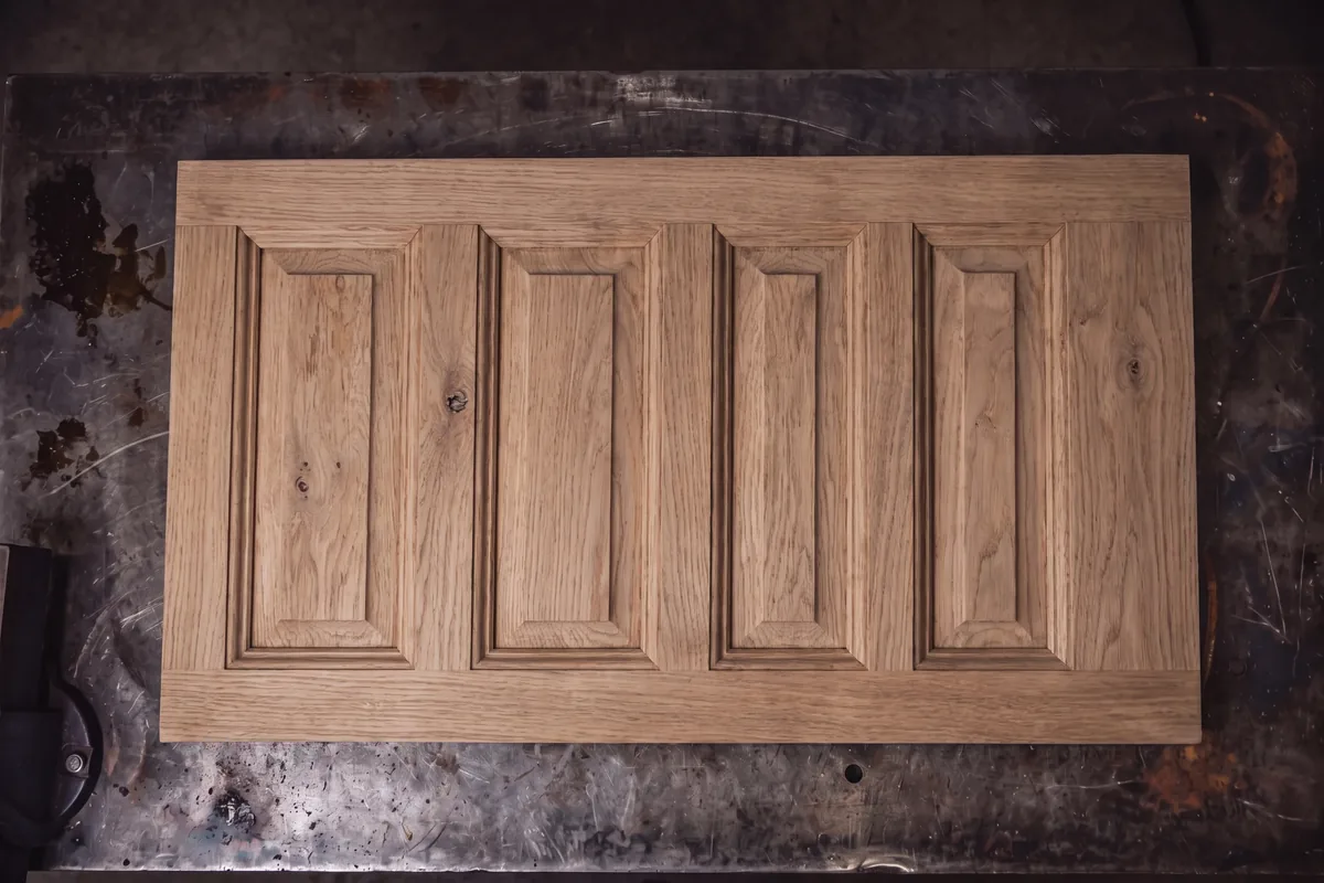 Same oak door panel stripped to clean bare wood grain by laser